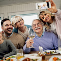 © Drazen Zigic | freepik.com | (Low angle view of happy extended family having fun while taking selfie after lunch at dining table) © Drazen Zigic | freepik.com | (Low angle view of happy extended family having fun while taking selfie after lunch at dining table)